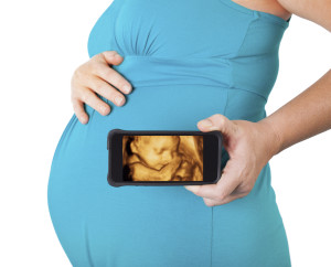 Preg mom holding smartphone w sonogram